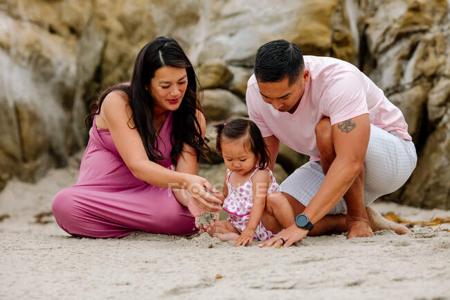 Young asian family having fun on the beach — Stock Photo