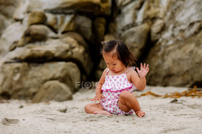 Lindo asiático bebé chica tener divertido en la playa - foto de stock