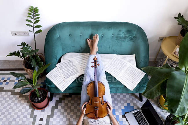 Girl lying on the floor with her legs raised surrounded by scores — Stock Photo