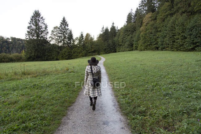 Mujer caminando a lo largo de un sendero hacia el bosque en Alemania - foto de stock