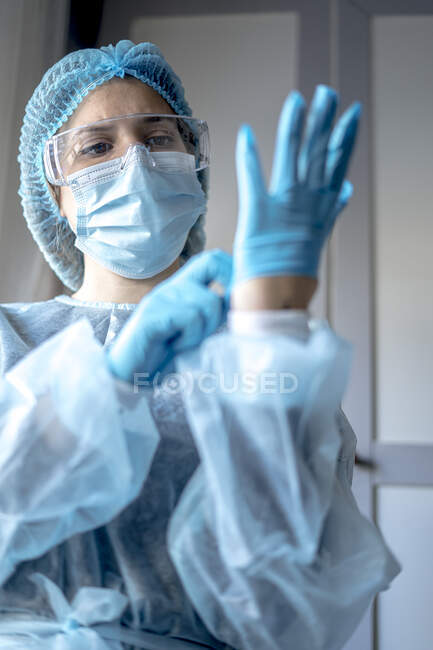Tema Medicina y Cirugía: el médico se pone guantes azules protectores - foto de stock