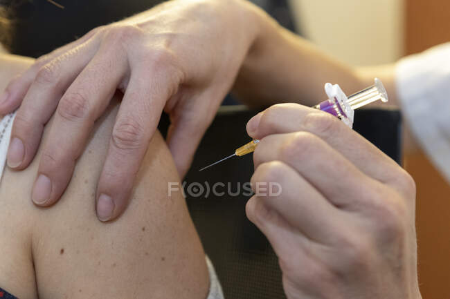 Gros plan de la femme qui reçoit l'injection du vaccin à l'hôpital — Photo de stock