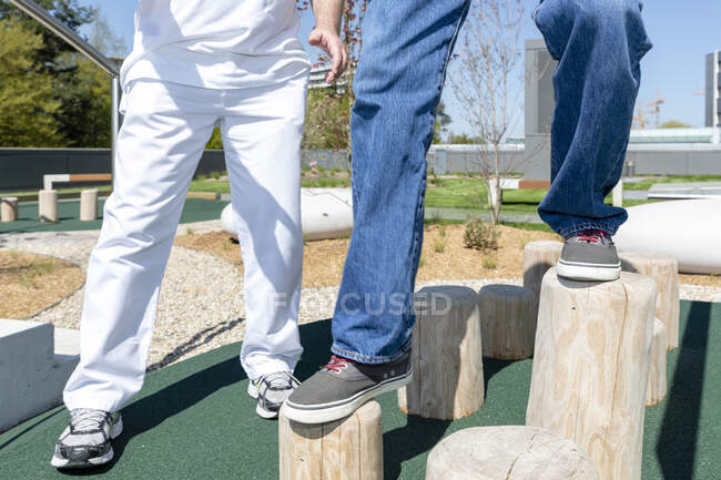 Cropped shot of patient and doctor making rehabilitation on playground — Stock Photo