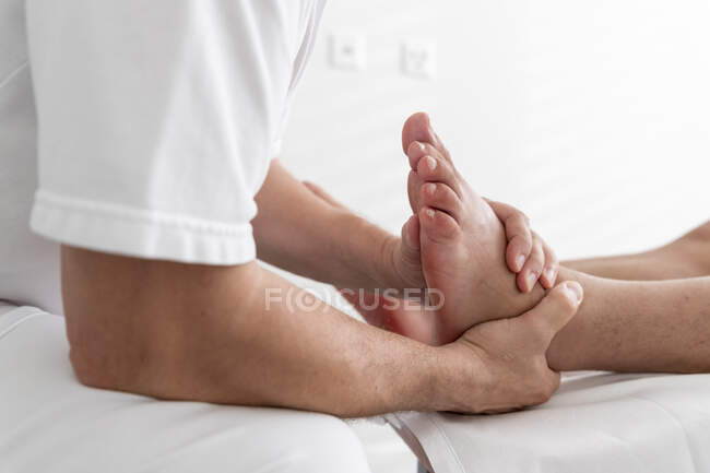 Professional massaging feet of patient in salon — Stock Photo