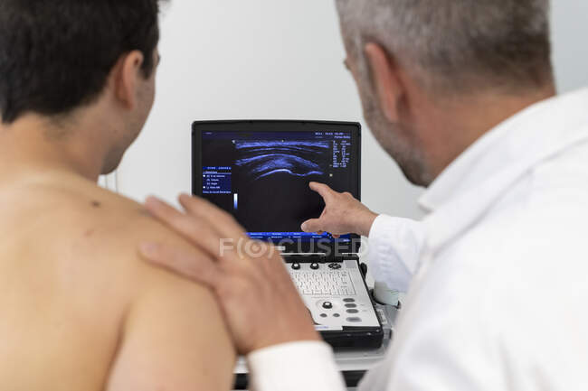 Medico di sesso maschile che esamina il paziente in ospedale — Foto stock