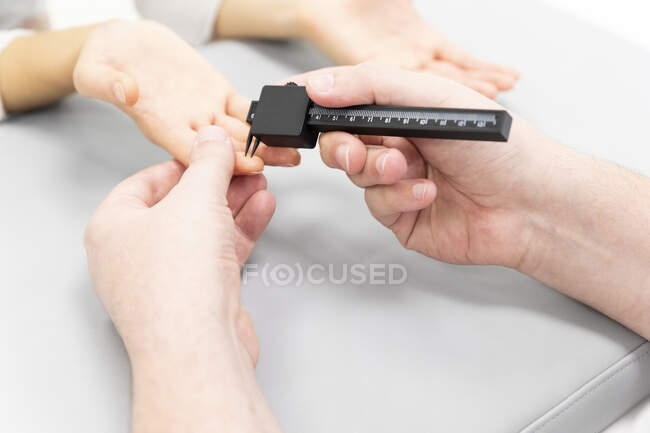 Inyección recortada del médico que mide el dedo del paciente - foto de stock