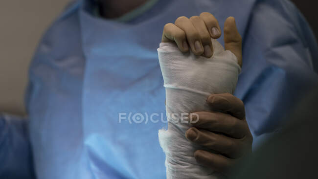 Plan recadré du médecin tenant la main du patient couvert de bandage — Photo de stock