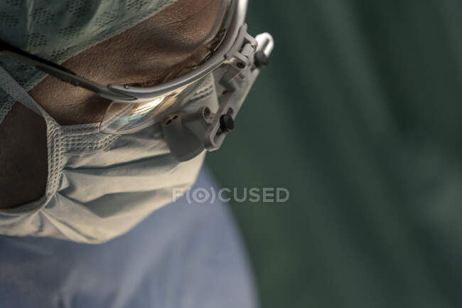 Primer plano de cirujano varón maduro con máscara y gafas - foto de stock