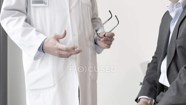 Inyección recortada de médico hablando con el paciente en blanco - foto de stock
