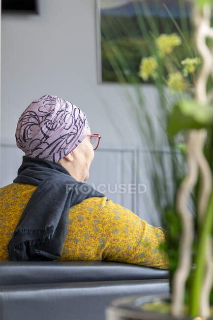 Rear view of mature woman sitting on couch in hospital — Stock Photo
