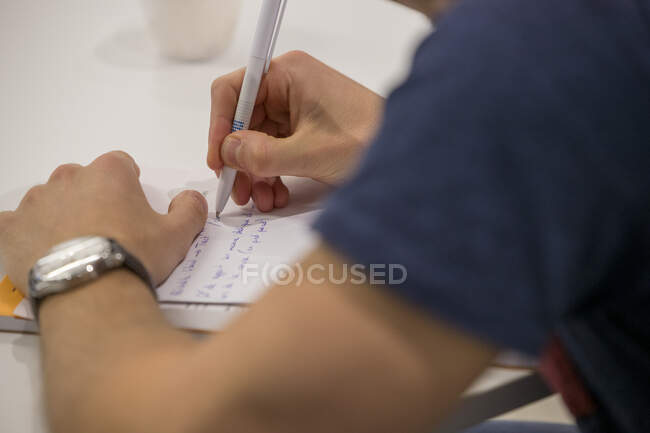 Зблизька чоловік пише ручку на записнику. — стокове фото