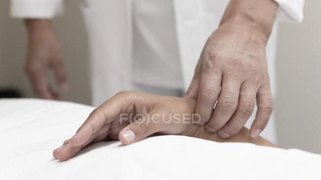 Tiro recortado del hombre que realiza la acupuntura para el paciente femenino - foto de stock