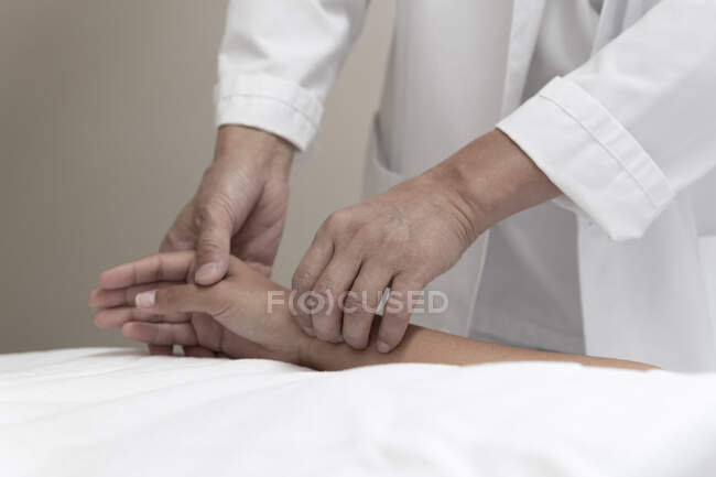 Обрезанный снимок мужчины, делающего иглоукалывание пациентке — стоковое фото