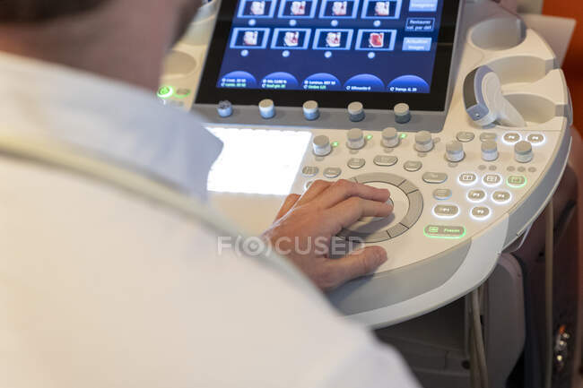 Primer plano del médico examinando el vientre de la mujer embarazada con ultrasonido - foto de stock