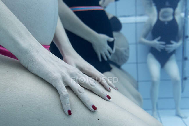 Cropped shot of group of pregnant women doing underwater exercises — Stock Photo