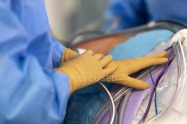Inyección recortada de enfermera tocando tubos de transfusión de sangre - foto de stock