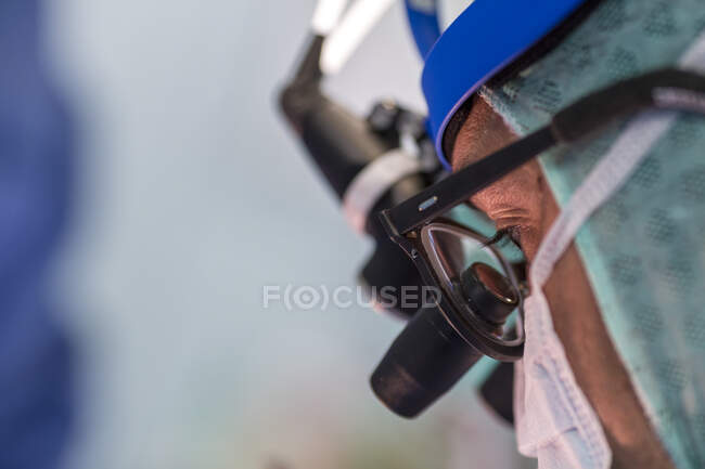 Primer plano del cirujano con prismáticos en el trabajo - foto de stock