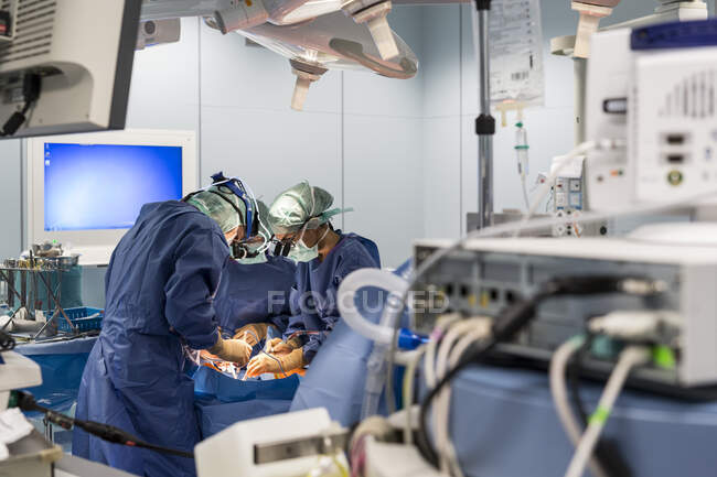 Grupo de cirujanos en quirófano en el trabajo - foto de stock