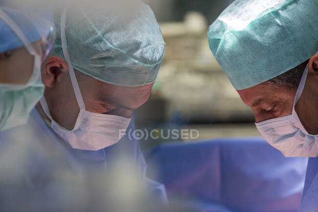 Grupo de cirujanos en quirófano en el trabajo - foto de stock