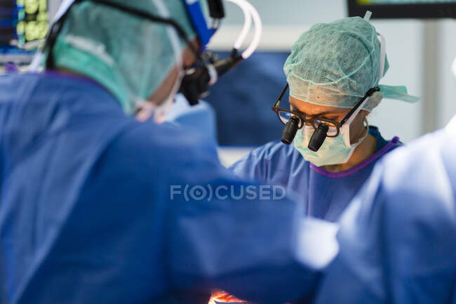 Groupe de chirurgiens en salle d'opération au travail — Photo de stock