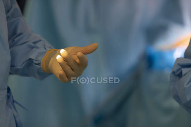 Mano del médico sosteniendo un anillo quirúrgico en sus manos - foto de stock