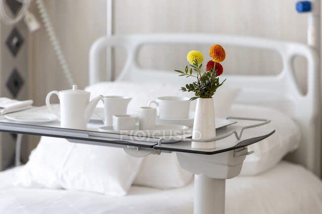 Modern bedroom interior with a cup of tea and flowers — Stock Photo