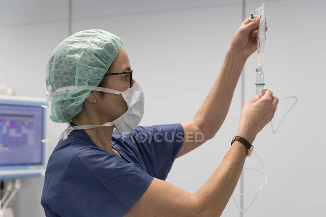 Uma jovem mulher está trabalhando com uma máscara em um hospital. — Fotografia de Stock