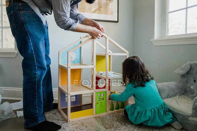 Батько і дочка працюють разом, щоб побудувати ляльковий будинок — стокове фото