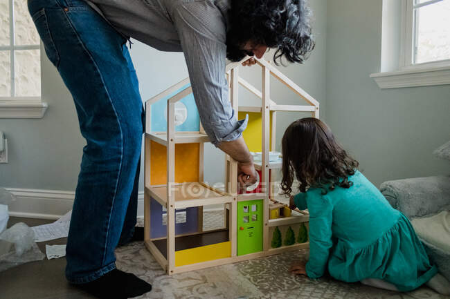 Padre e hija construyendo una casa de muñecas - foto de stock