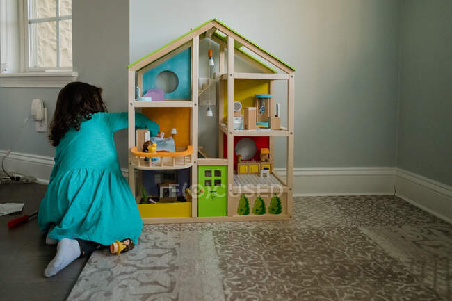 Kleines Mädchen spielt mit einem Puppenhaus — Stockfoto
