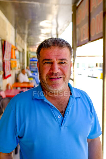 Un venditore giordano sorride fuori dal suo negozio al Castello di Kerak, Giordania — Foto stock