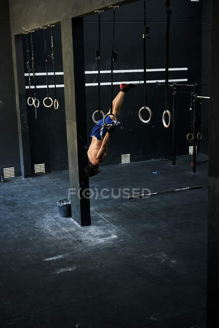 Shirtlos fitter junger Mann trainiert mit hängenden Ringen — Stockfoto