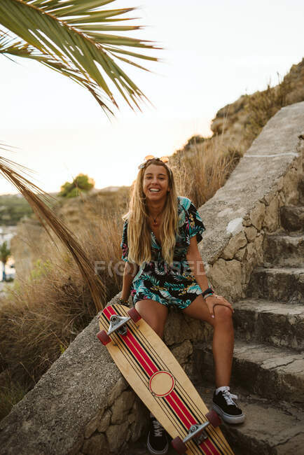Jeune femme skateboarder sur la plage — Photo de stock