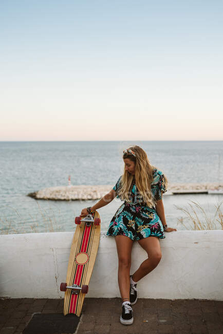 Young woman skateboarder on the beach — Stock Photo