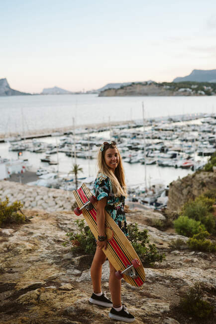 Jovem mulher skatista na praia — Fotografia de Stock
