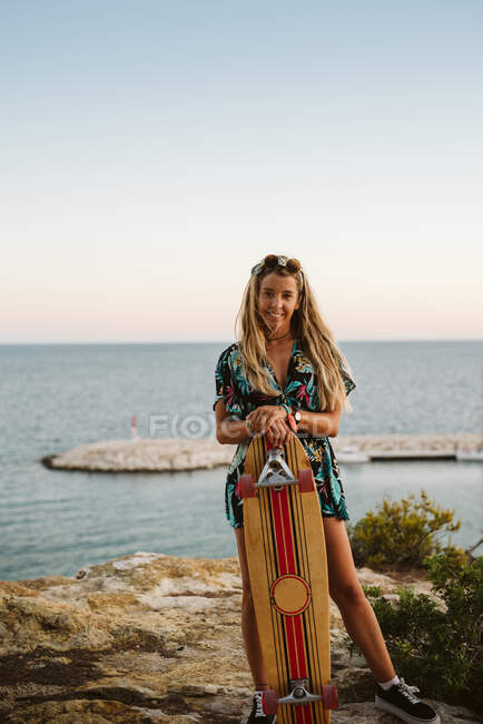 Jovem mulher skatista na praia — Fotografia de Stock