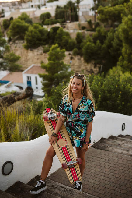 Jeune femme skateboarder sur la plage — Photo de stock