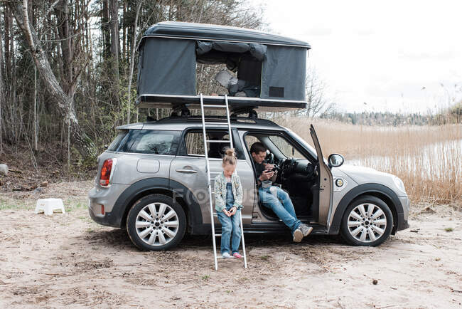 Family camping by the beach in roof top tent — Stock Photo
