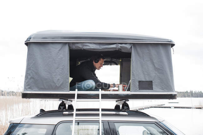 Mann arbeitet im Zelt mit Blick auf soziale Distanz zum Büro — Stockfoto