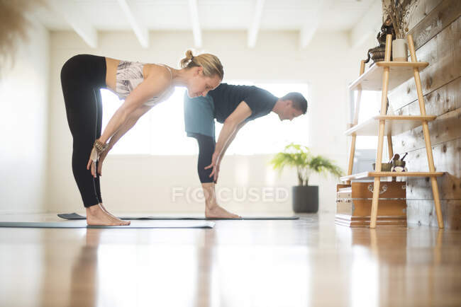 Ein Paar dehnt sich beim Yoga. — Stockfoto