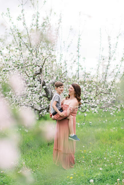 Мати з сином у квітучому яблучному саду в Новій Англії. — стокове фото