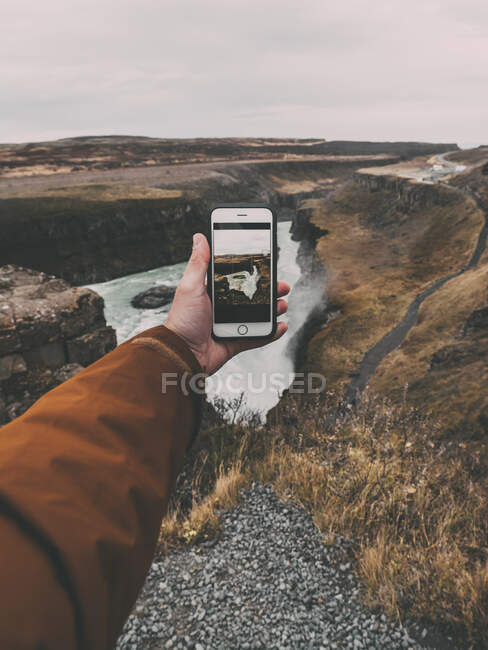 Fotógrafa femenina tomando fotos con una cámara en las montañas, un hombre con una mochila en la espalda - foto de stock