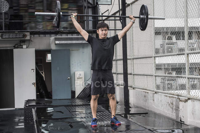 Man training at rooftop gym in Bangkok — Stock Photo