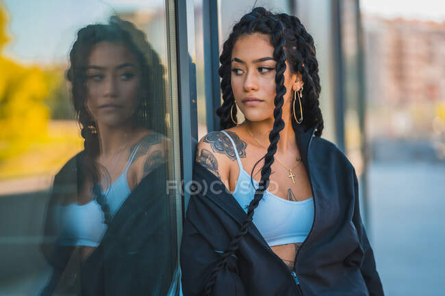 Young black girl with braids looking in a mirror — Stock Photo