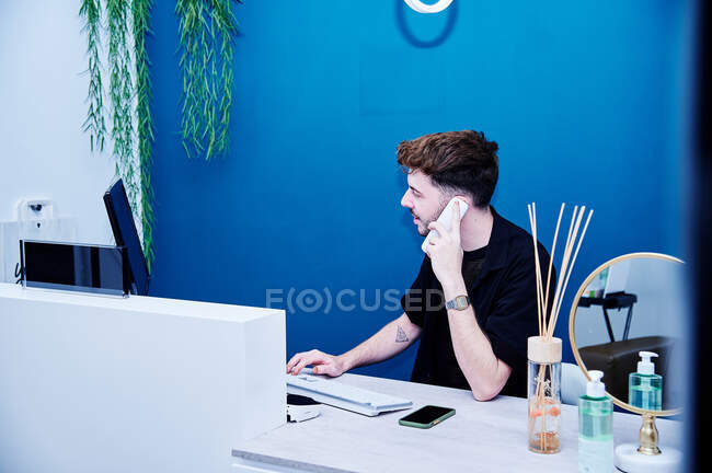 Stilista parlando con il cliente per fissare un appuntamento — Foto stock