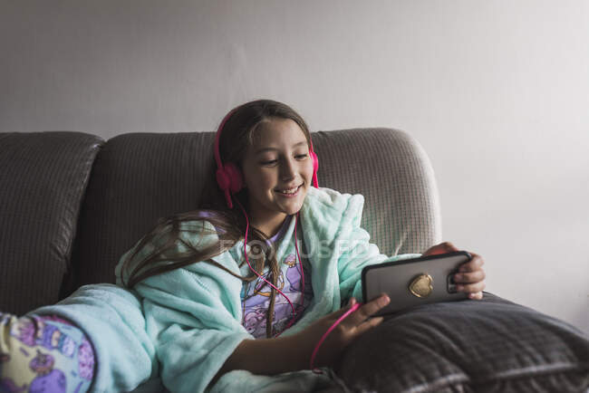 Linda niña viendo videos en el smarthpone - foto de stock