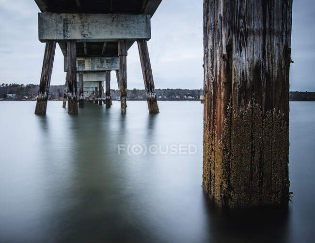 Longue exposition de l'eau de mer et des pieux sous le pont Yarmouth, Maine — Photo de stock