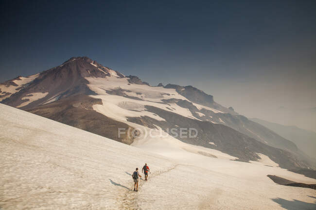 Climbers descend a trail on a snowfield after climbing Glacier Peak in the Glacier Peak Wilderness in Washington. (released: Sam Thompson and Brock Gavery) — Stock Photo