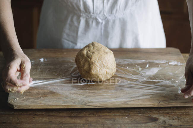 Baker making dough for bread on a wooden table — Stock Photo