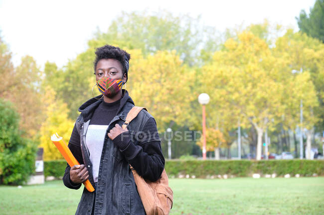 Étudiante africaine de l'université portant un masque protecteur sur le campus. Nouvelle normale au collège. — Photo de stock